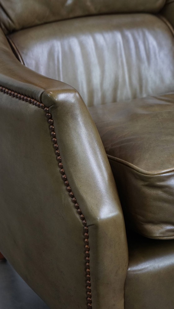 Image 1 of Poltrona in pelle di mucca verde oliva rifinita con chiodi decorativi