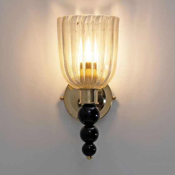 Image 1 of Een paar Italiaanse wandlampen van Murano-glas met goudstofaccenten en messing.