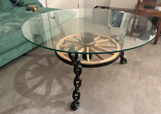 Image 1 of Tafel in de vorm van een wagenwiel met een massief glazen blad.