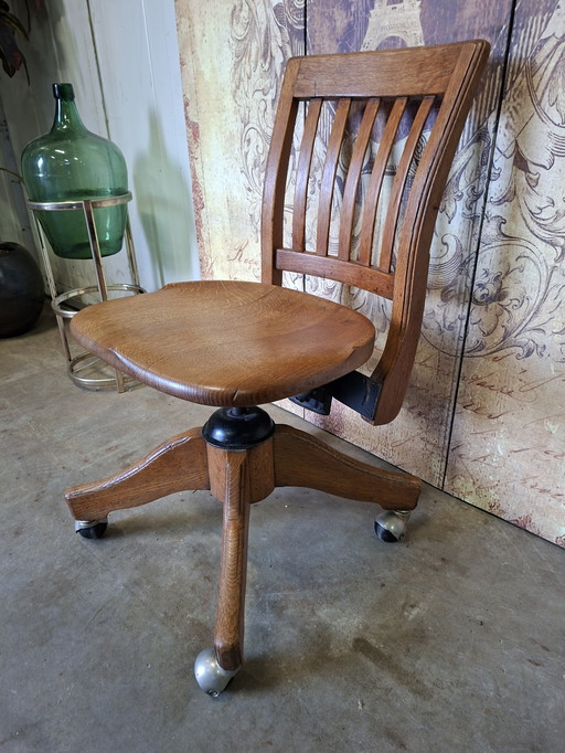 Antieke verstelbare, draaibare bureaustoel van eikenhout gemaakt door de H. Krug Furniture Company afm.42x50cm en 78cm hoog.
