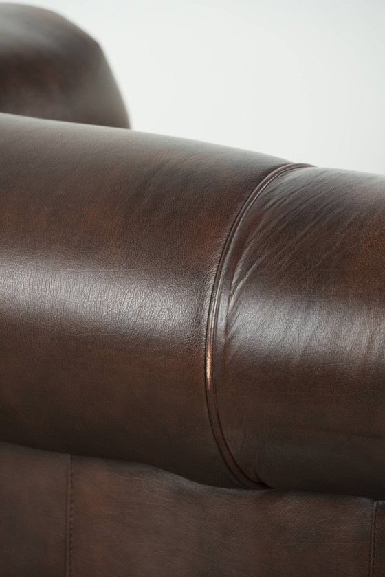 Image 1 of Conjunto de lujo de piel de vacuno marrón compuesto por un sofá Chesterfield liso y un sillón.