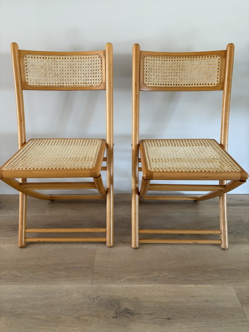 Twee vintage inklapbare houten met webbing stoelen 