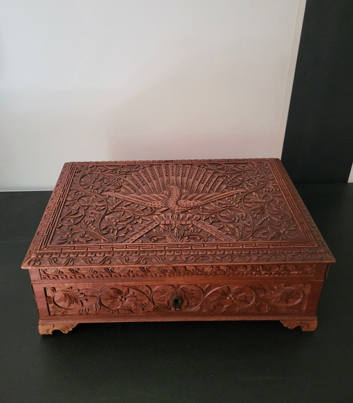 Hand-engraved wooden jewelry box with peacock and floral motifs.