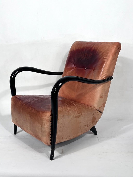 Sillón escultórico italiano de mediados de siglo XX, tapizado en cuero y madera curvada, de los años 50.