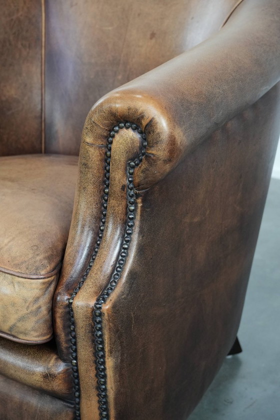 Image 1 of Clubfauteuil gemaakt van schapenleer afgewerkt met siernagels