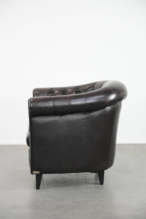 Image 1 of Donkere luxe rundleren Chesterfield clubfauteuil in Engelse stijl, afgewerkt met siernagels