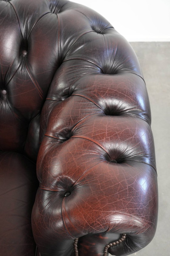 Image 1 of Canapé Chesterfield 2 places en cuir de vachette anglais ancien rouge/marron, au style magnifique et au charme intemporel.