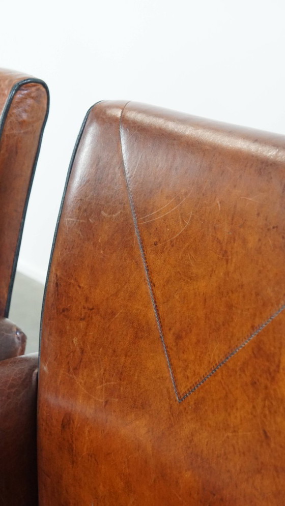 Image 1 of 4 x Vintage schapenleren eetkamerstoel met zwarte biezen op wieltjes