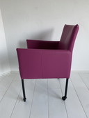 Luxurious fuchsia leather dining chairs with wheels
