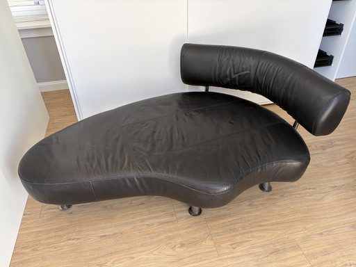 Divano Cheselong, design nero, rivestimento in pelle, gambe in acciaio.