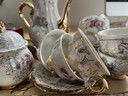 Vintage theeservies met gouden details en bloemmotief 