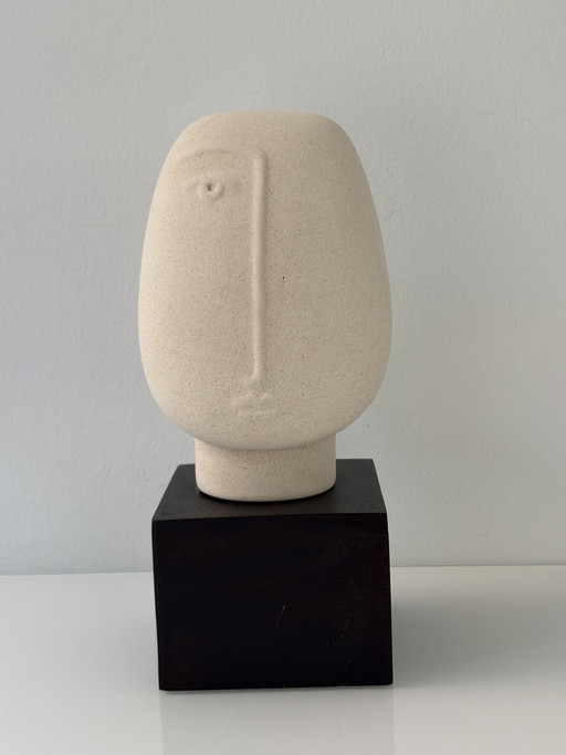 Statue of an abstract face in rough ceramic