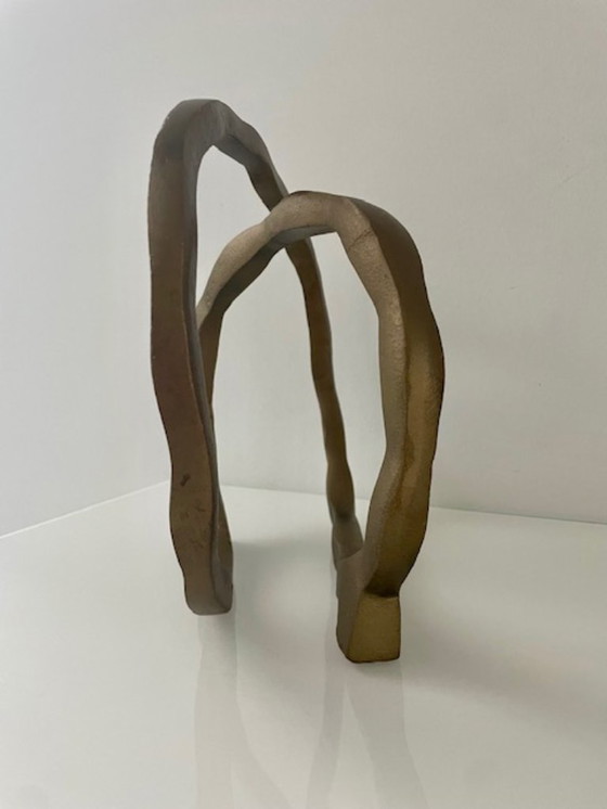 Image 1 of Escultura de diseño con forma de anillo abierto en oro mate.