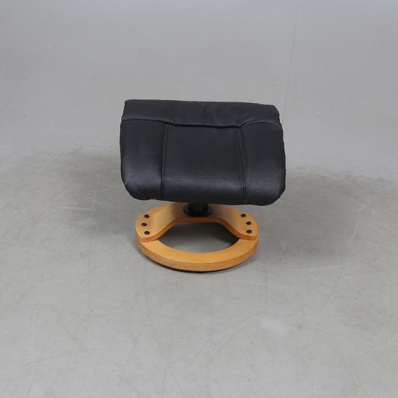 Image 1 of Sweden-origin Scandinavian lounge armchair with a matching ottoman, featuring a black leather and wood frame, in good condition 