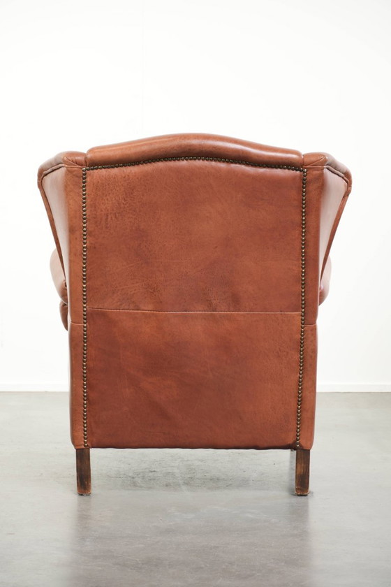 Image 1 of Poltrona a orecchioni color cognac chiaro, rivestita in pelle bovina, dal caratteristico look inglese.