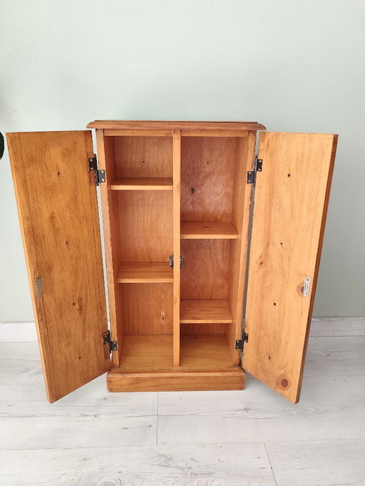 Pequeño mueble de madera estilo armario con cajones falsos