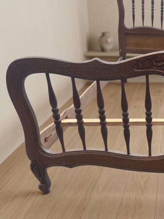 Image 1 of Vintage houten bedframe met houtsnijwerk, sierlijk hoofd- en voetbord, eerste helft 20e eeuw