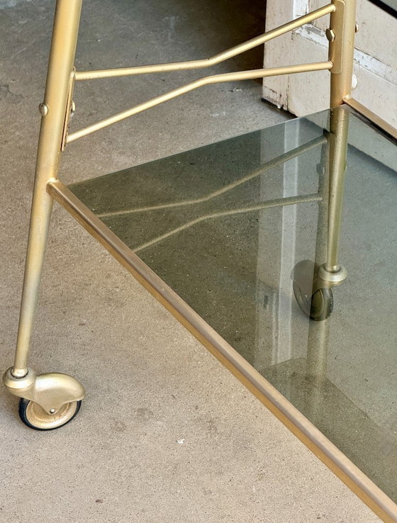 Image 1 of Carrello di servizio a due livelli in vetro fumé e metallo dorato