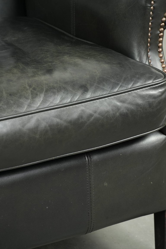 Image 1 of Zwarte rundleren oorfauteuil in een klassiek Engelse stijl