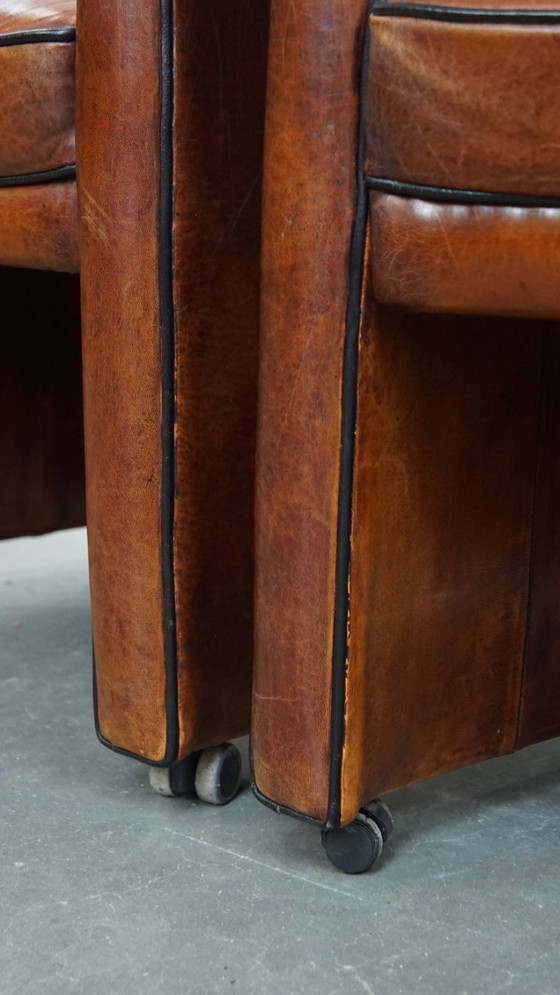 Image 1 of 6 x Vintage sheepskin dining chair with black piping on wheels