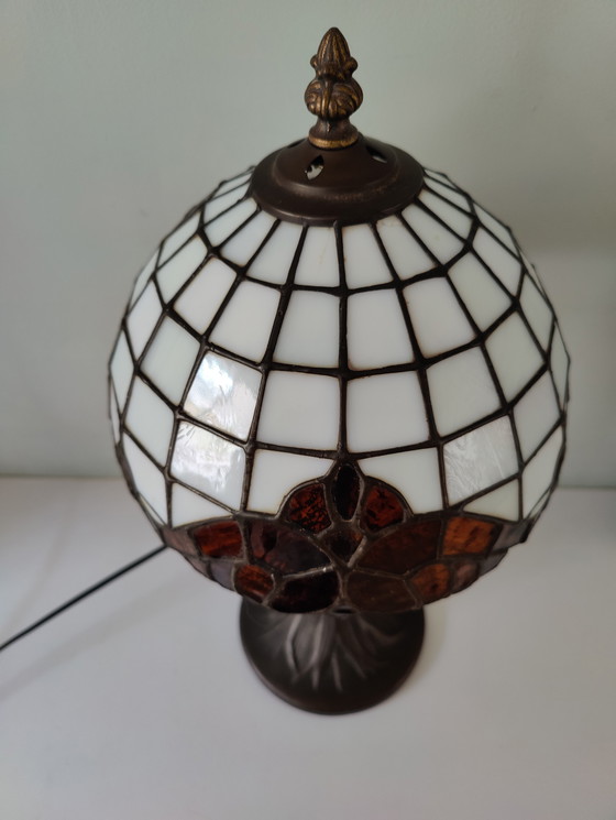 Image 1 of Lámpara de mesa estilo Tiffany con pantalla de vidrieras y base de bronce.