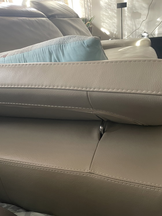 Image 1 of Grijze leren bank met verstelbare hoofd-arm leuningen.