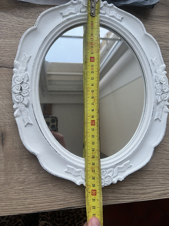 Image 1 of Specchio ovale in legno bianco con intagli floreali.