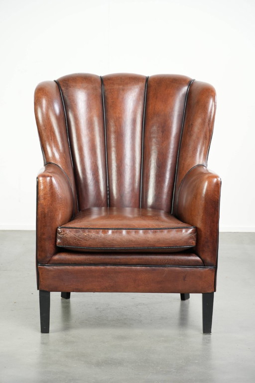 Fauteuil unique en peau de mouton aux couleurs chaudes et profondes, orné d'un passepoil noir. – Leather (photo 2 of 14)