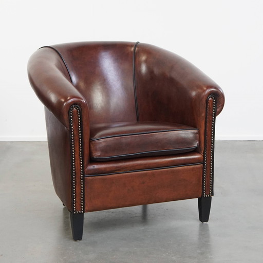 Fauteuil club en peau de mouton avec passepoil noir