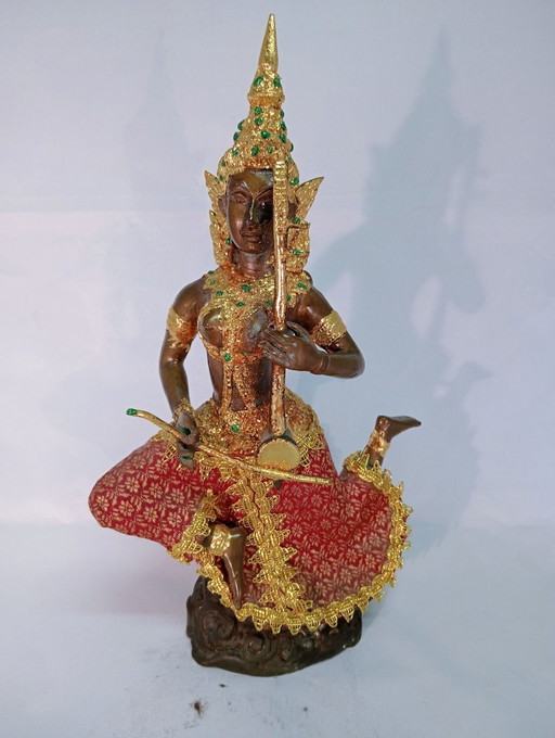 Asian sculpture of a musical figure, bronze-colored