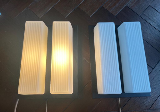2 Mid - Century wall lamps with pull switch or for direct mounting. Frosted glass on metal body with flat silhouette, 60s
