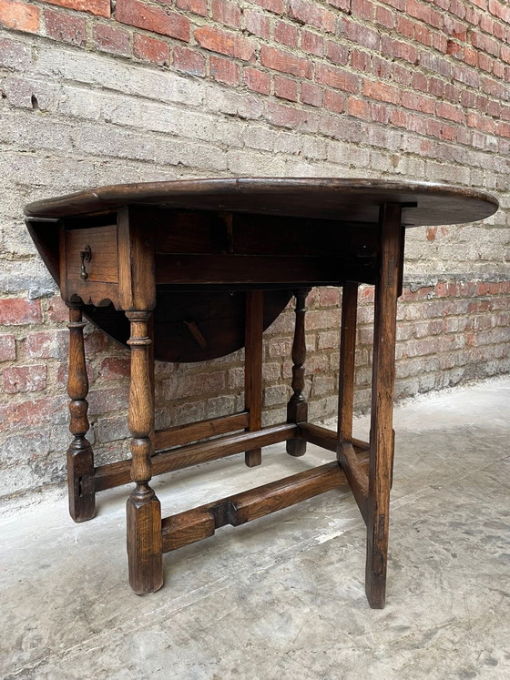 Image 1 of Tavolo antico in rovere con gambe a ribalta e cassetto