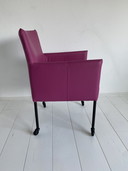 Luxurious fuchsia leather dining chairs with wheels
