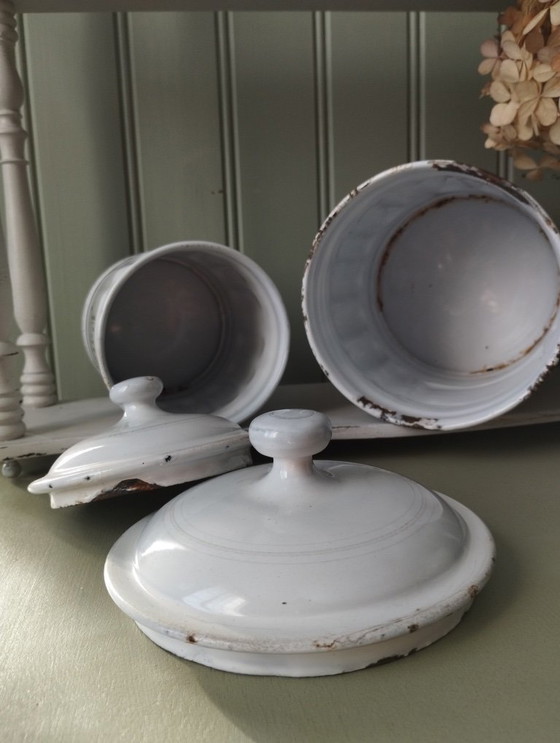 Image 1 of Antieke dozen gemaakt van wit geëmailleerd plaatmetaal met gegroefde randen en gouden versiering.