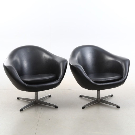 Paire de fauteuils pivotants vintage en similicuir noir avec pieds chromés, datant des années 1980-1990 et en bon état.