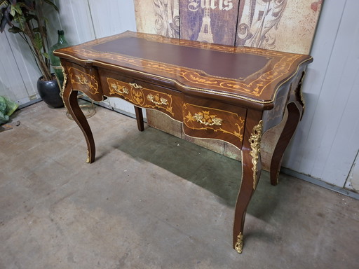 Scrivania antica in stile barocco, con intarsi. Dimensioni: 122x61 cm e altezza 79 cm.