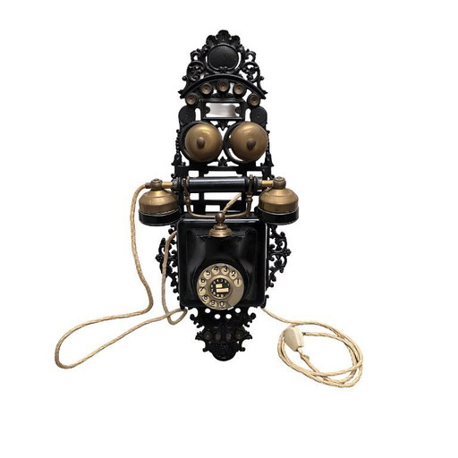 Ancien téléphone mural à cadran rotatif en fonte, début des années 1900