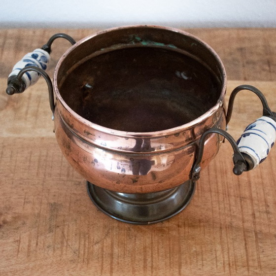 Image 1 of Vintage bloempot op voet uit de jaren '50 van koper, messing en Delfts blauw porselein