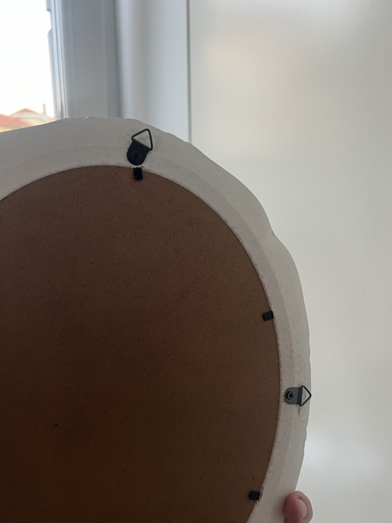 Image 1 of Specchio ovale in legno bianco con intagli floreali.