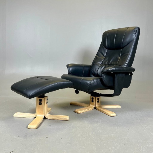 Two‑piece lounge set by Ekornes comprising a swivel reclining armchair and a matching footstool in black leather with a wood fra