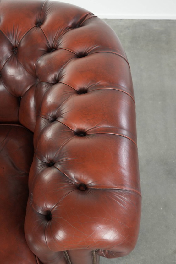 Image 1 of Beautiful red/brown cowhide Chesterfield armchair in a classic English style