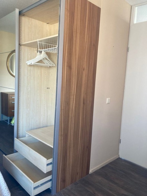 Image 1 of Armario moderno IKEA PAX que va desde el suelo hasta el techo, con puertas correderas de cierre suave.