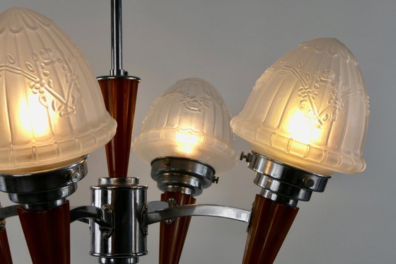 Image 1 of Chrome Art Deco chandelier with four amber Bakelite torches with decorated glass lampshades, ca. 1935
