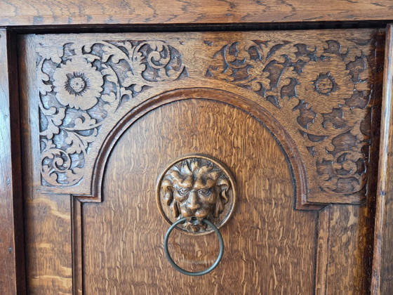 Image 1 of Armoire ancienne en chêne ornée de têtes de lion