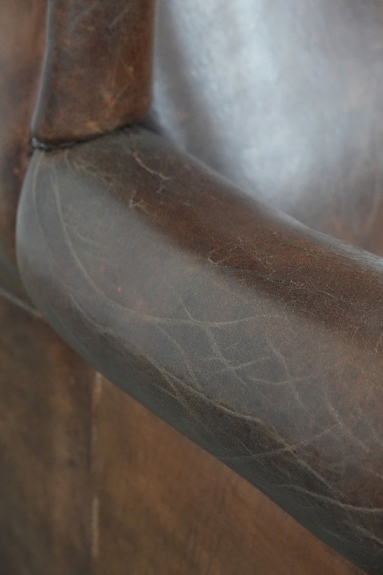 Image 1 of Caratteristica poltrona vintage di grandi dimensioni con ali laterali, realizzata in pelle di pecora.