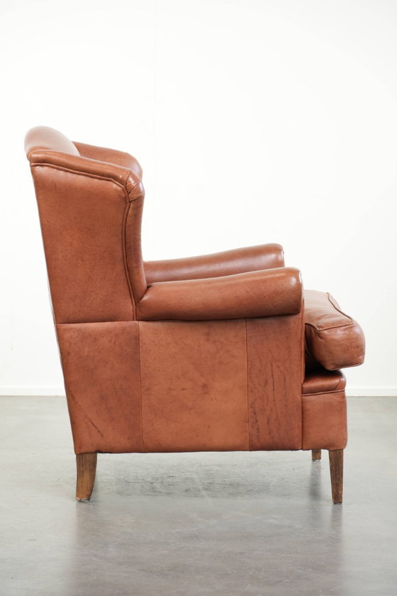 Image 1 of Poltrona a orecchioni color cognac chiaro, rivestita in pelle bovina, dal caratteristico look inglese.