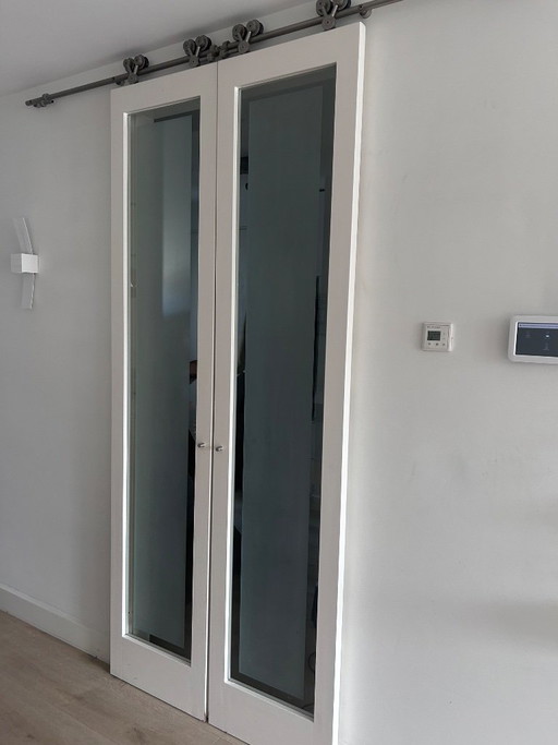 White sliding doors with frosted glass and industrial rail