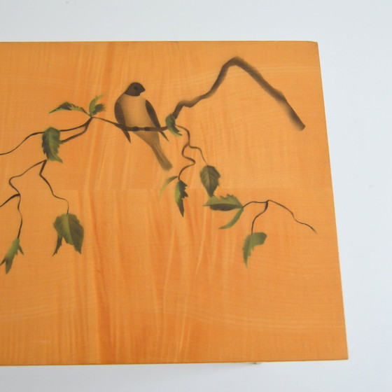 Image 1 of Pretty coffee table from the 50s/60s.  Decorated with a bird on a branch.  Black brass-finish tapered legs.  L 80/ W 40/ H 51