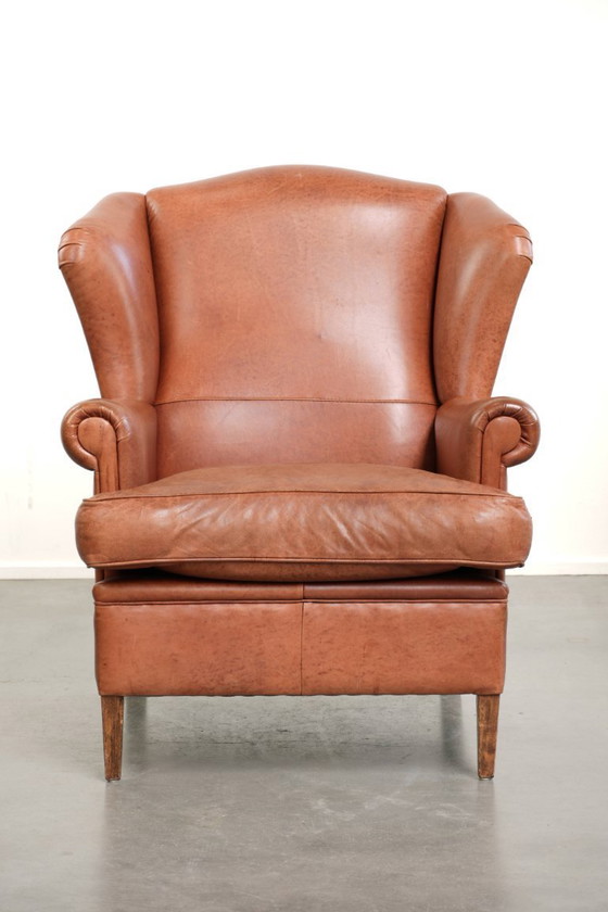 Image 1 of Poltrona a orecchioni color cognac chiaro, rivestita in pelle bovina, dal caratteristico look inglese.