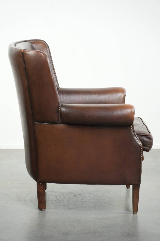 Wunderschöner, dezenter Ohrensessel aus Schaffell in einem tiefen Cognac-Ton mit bequemer Sitzfläche (photo 3 of 12)